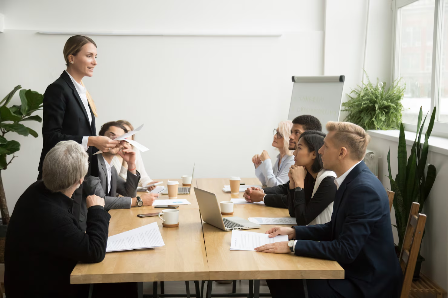 A leader presenting to colleagues around a conference table.