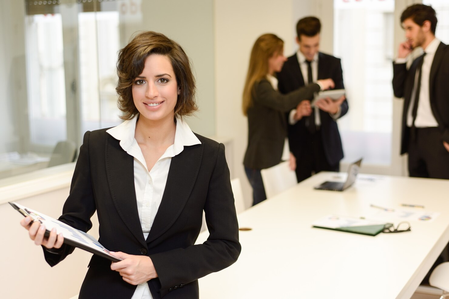 A business leader with colleagues working in an office.