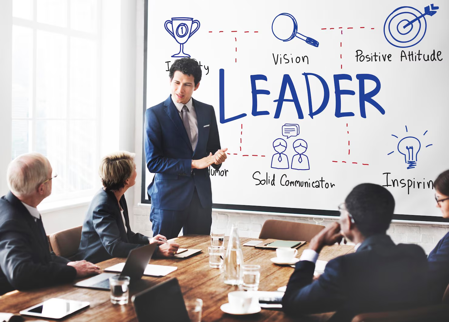 A leader presenting leadership principles to colleagues around a meeting table.